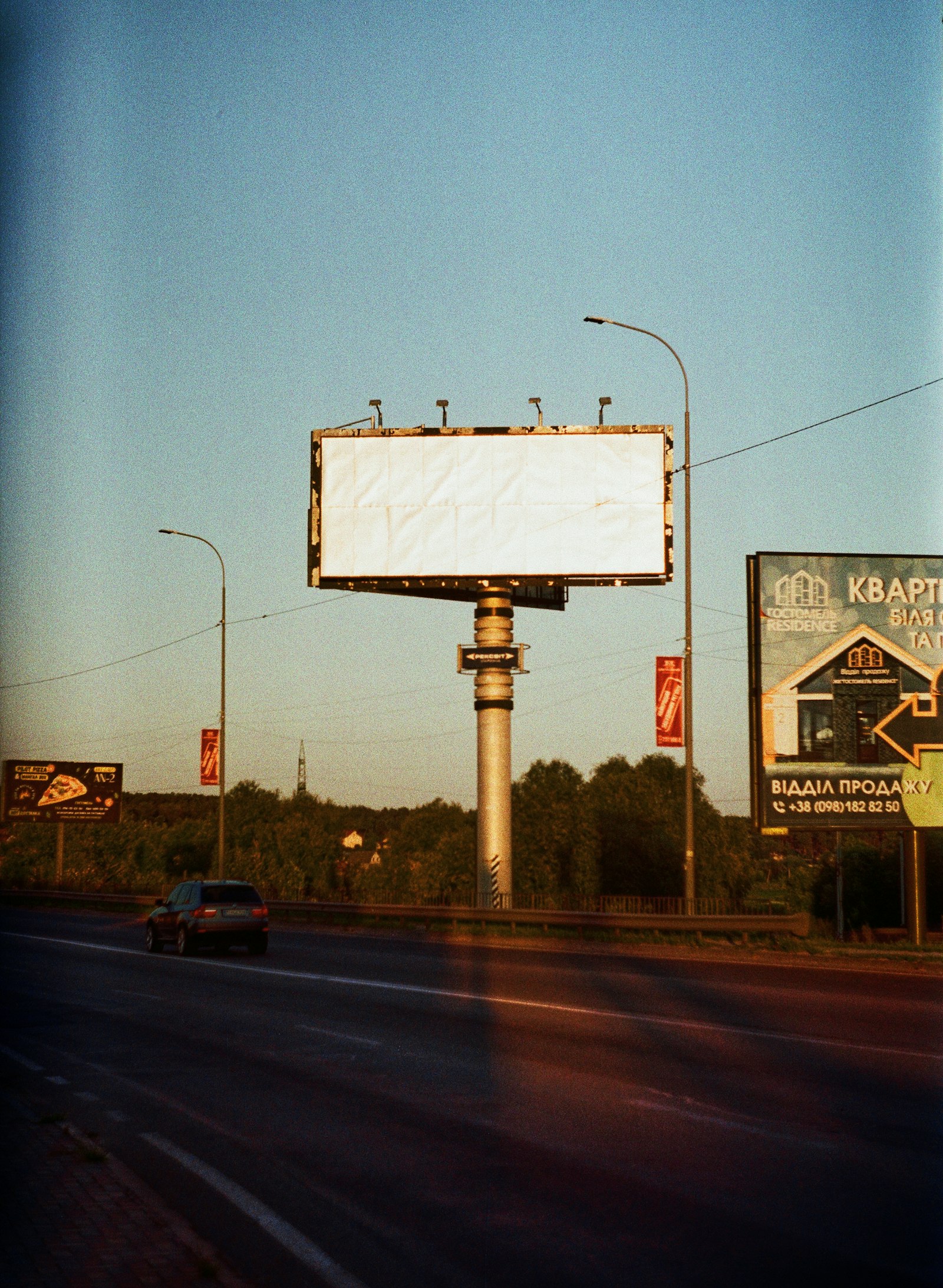 Alacakaranlıkta ana yol kenarında büyük bir billboard